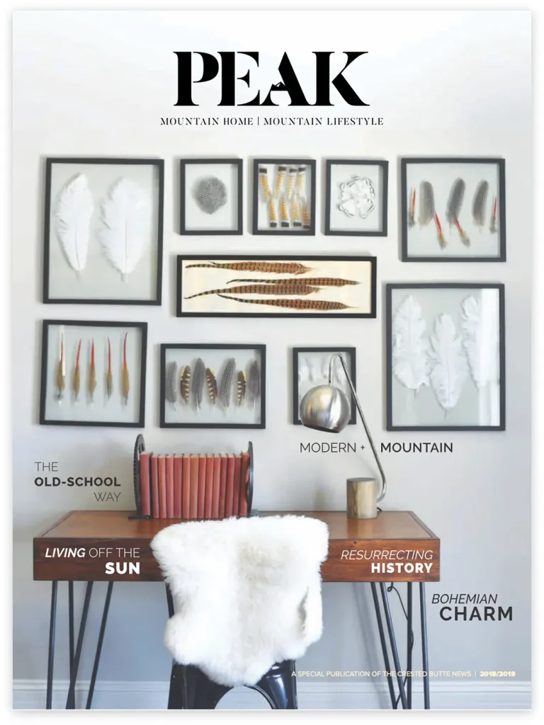 Magazine cover of PEAK highlighting mountain lifestyle with a bohemian home office setup, feather artwork, and rustic furnishings in a cozy, modern interior.