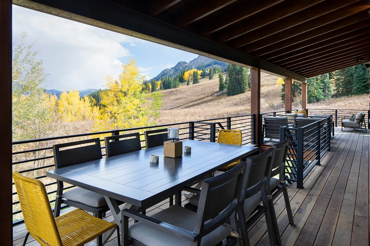 Outdoor dining deck at Surround House with panoramic alpine scenery and yellow aspens.