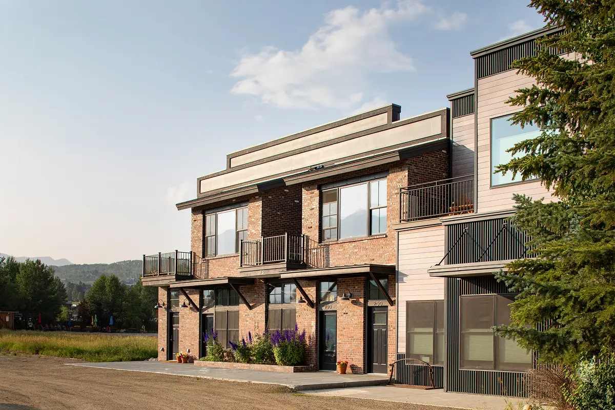 South-facing apartments above commercial storefronts with brick façade and private balconies in Crested Butte South.
