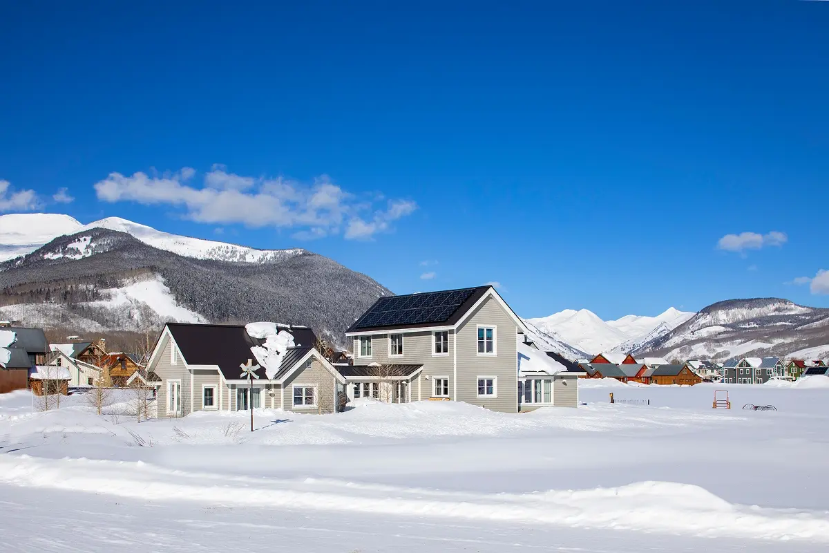 Barn design in Crested Butte using reclaimed wood and rustic materials on snowy open land.