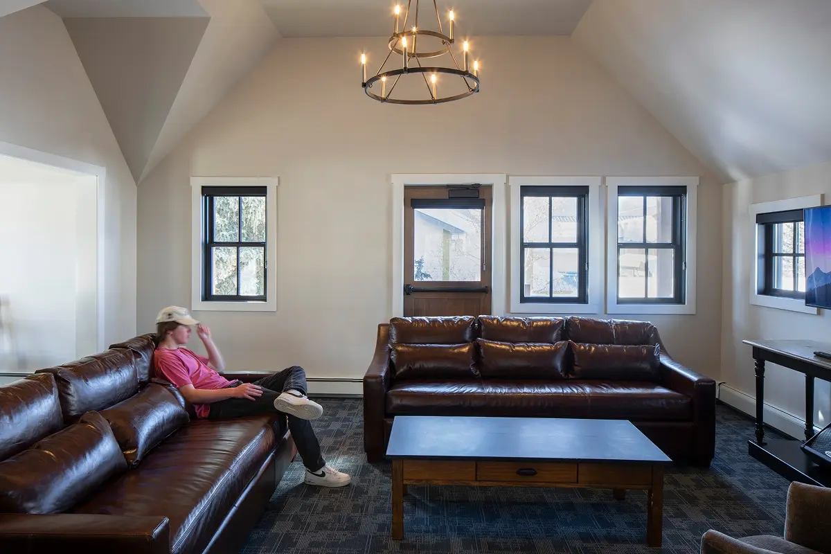 Casual gathering room with leather couches and TV in a warm Crested Butte community space.