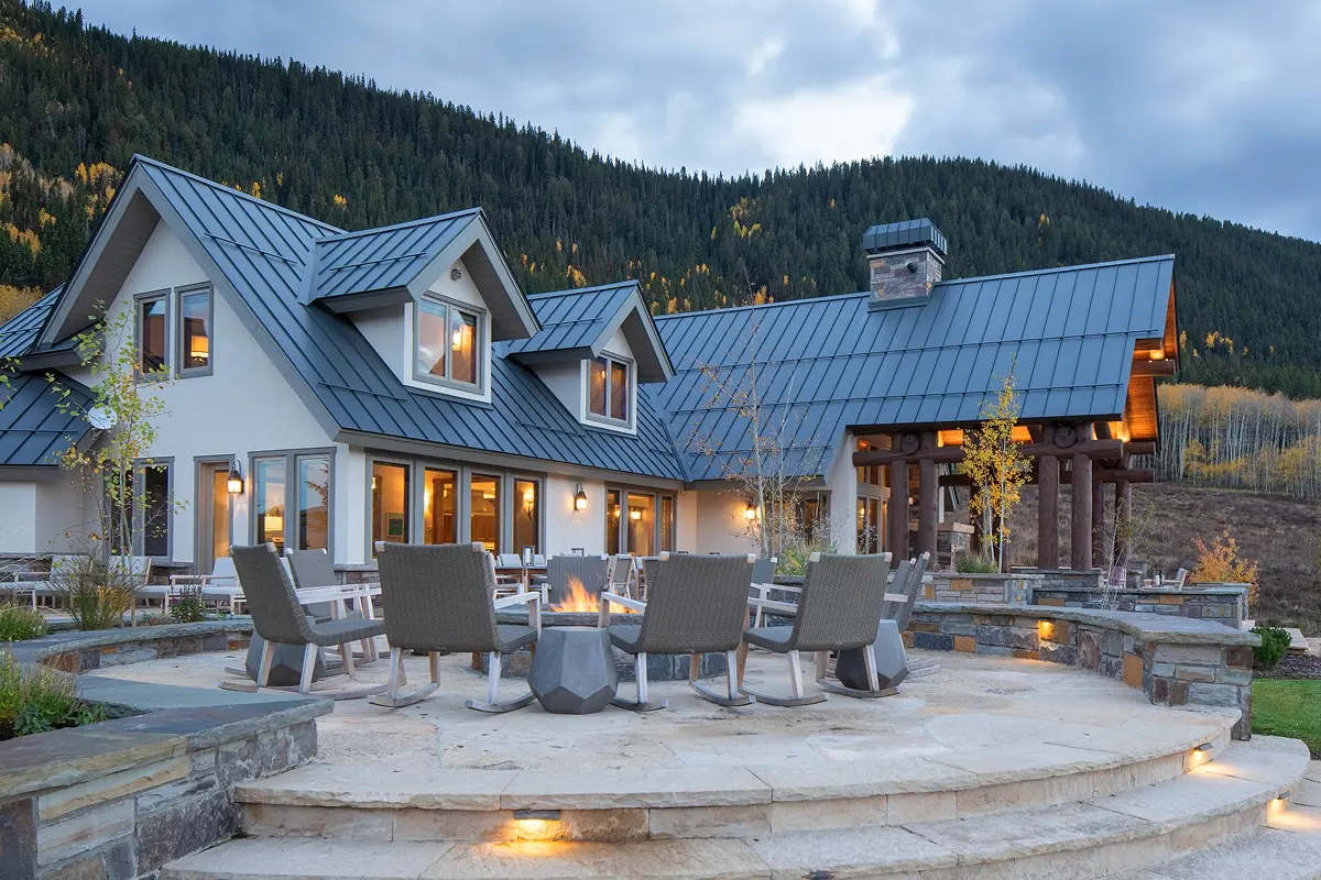 Circular lounge seating around a central firepit with views of the surrounding mountain landscape.
