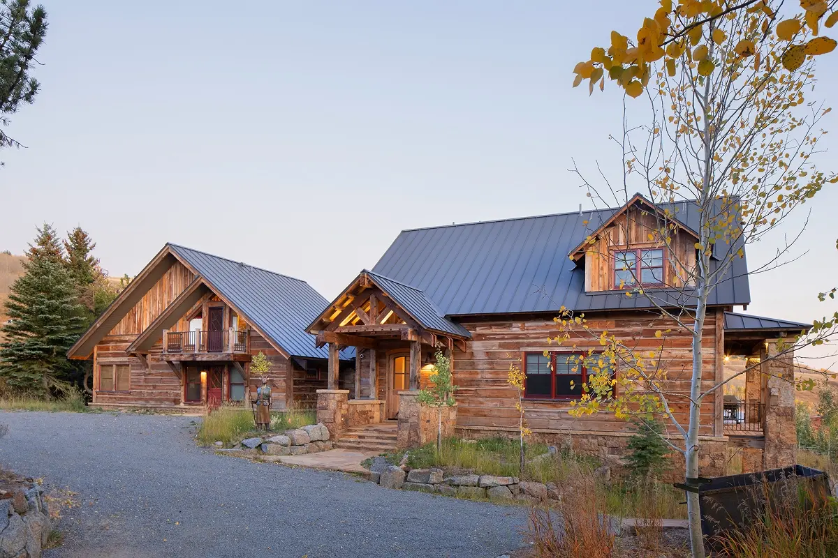 Front exterior of Crested Butte home with log entry porch and gravel driveway.