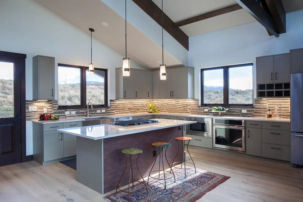 Contemporary kitchen with quartz island, modern pendants, and exposed structural beams in a Crested Butte home.