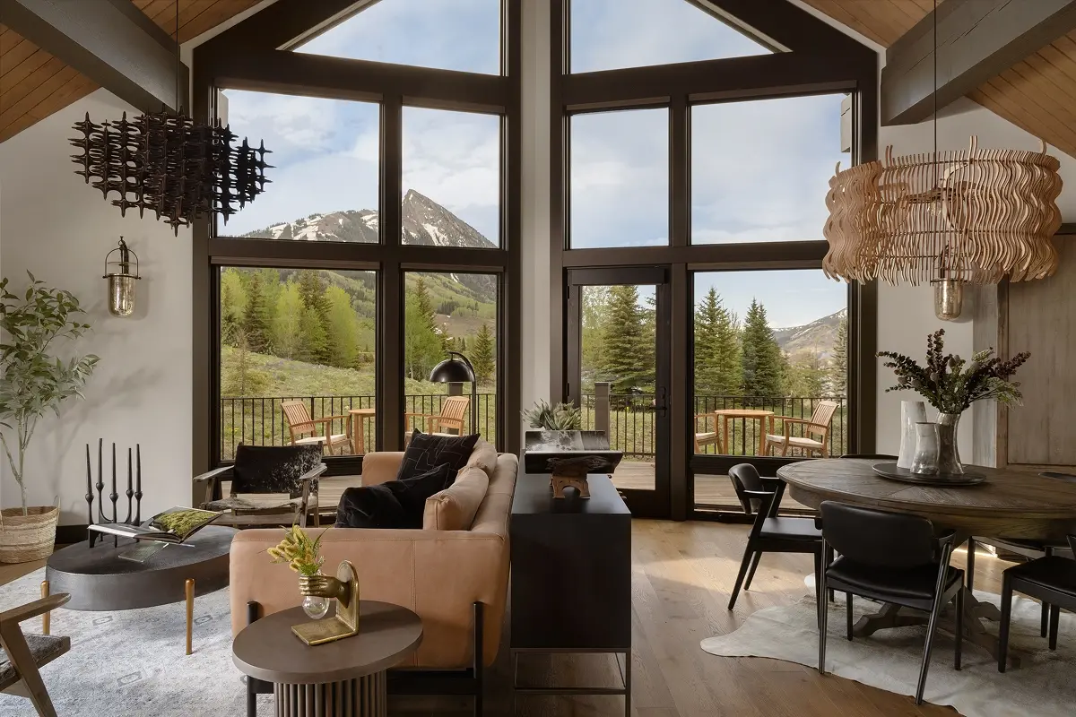 Modern mountain living room with expansive windows framing Mount Crested Butte and sculptural lighting fixtures.