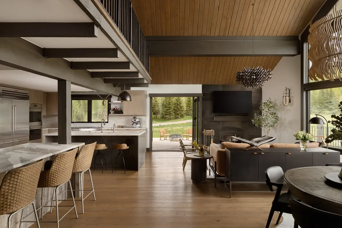 Renovated kitchen and living space with central fireplace, exposed beams, and outdoor access to deck and firepit.