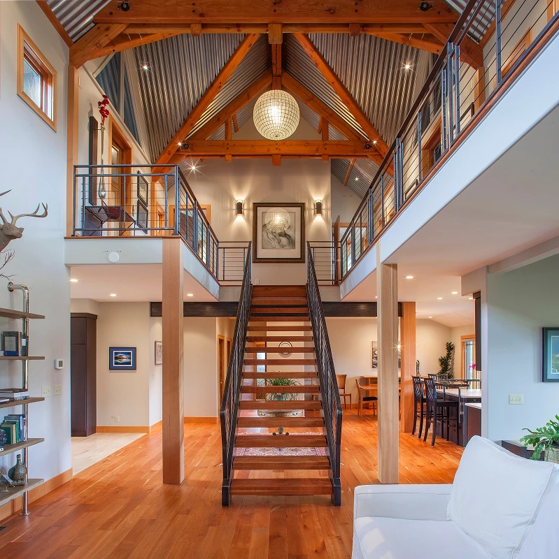 Central staircase renovation with steel railings and vaulted ceiling, creating a dramatic light-filled entry.