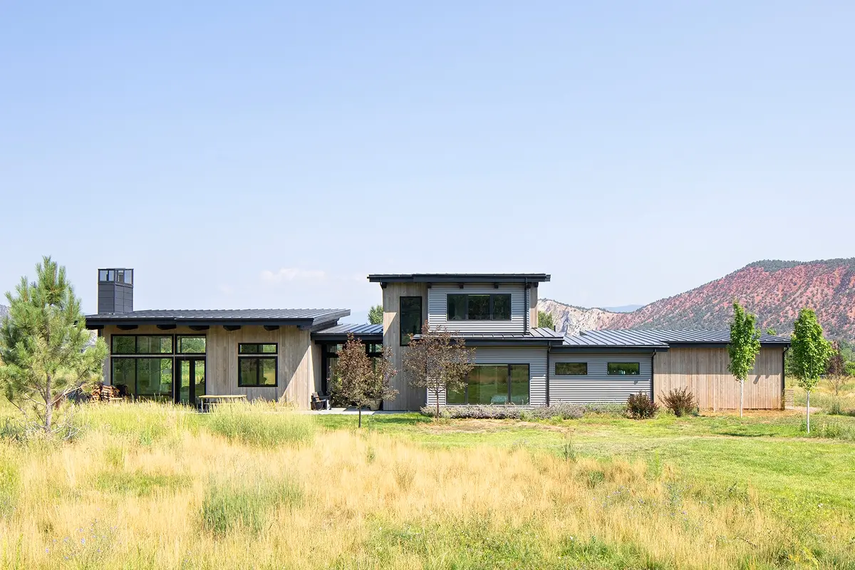 Luxury home design with mountain backdrop and clean modern forms across varied volumes.
