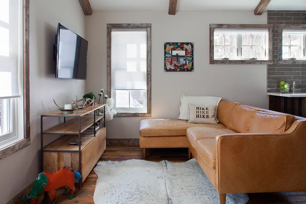 Living space with leather sectional and natural light in renovated Crested Butte cabin.