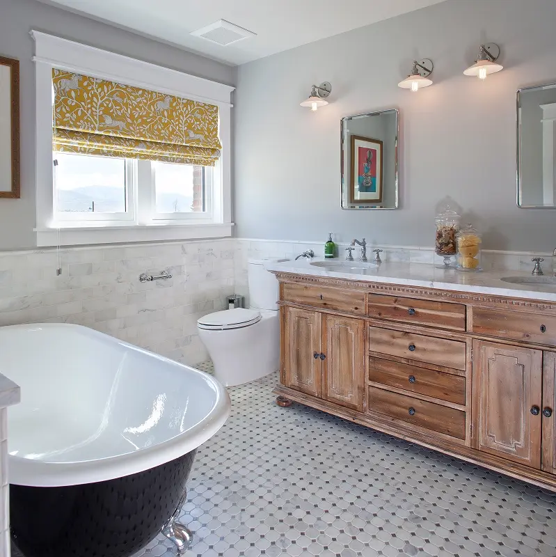Rustic bathroom with clawfoot tub, antique wood vanity, hex tile floor, and marble wainscoting in Crested Butte home.