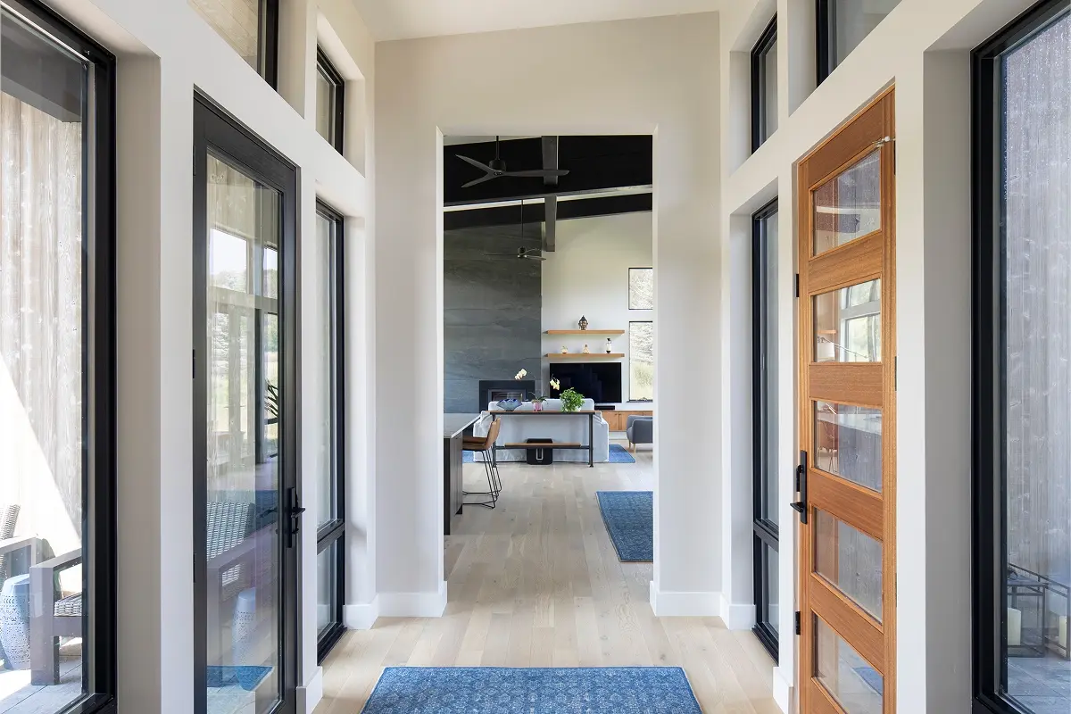Glass entryway by mountain architect featuring pond views and sleek, minimalist design.