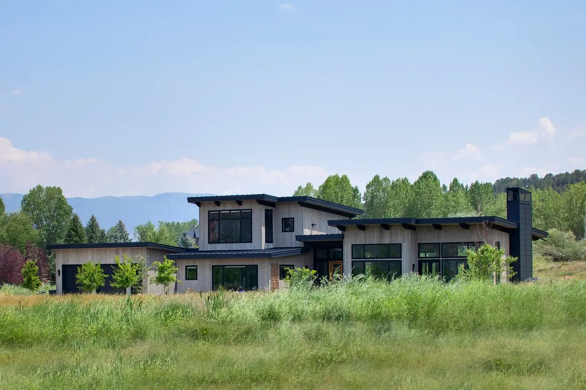 Mountain architecture with low-slung shed roofs and wood siding set in the Colorado landscape.