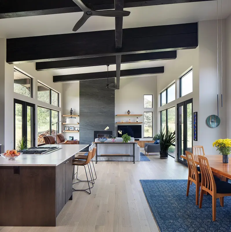 Mountain modern open living space with floor-to-ceiling glass and expansive indoor-outdoor flow.
