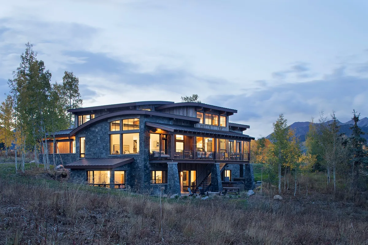 Full rear elevation of Surround House with expansive deck and three-story staircase.