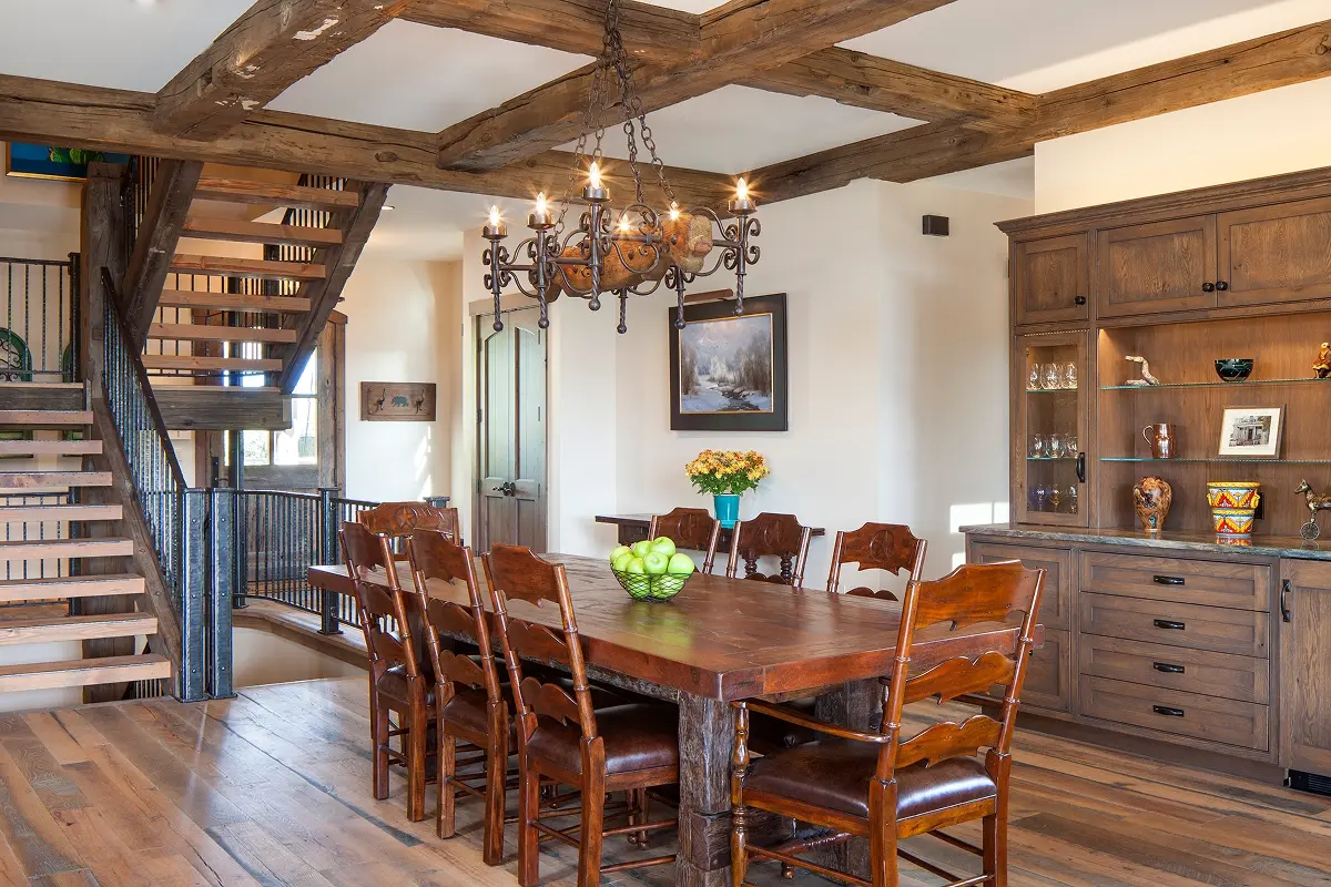 Open layout with rustic wood staircase and dining area in mountain home.