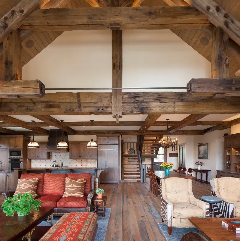 Open great room with vaulted timber ceiling spanning kitchen, living, and dining areas.